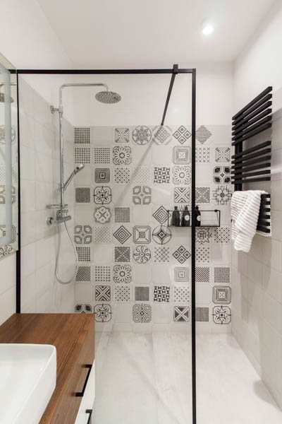 Jasna łazienka z płytkami w geometryczne patchworkowe wzory.